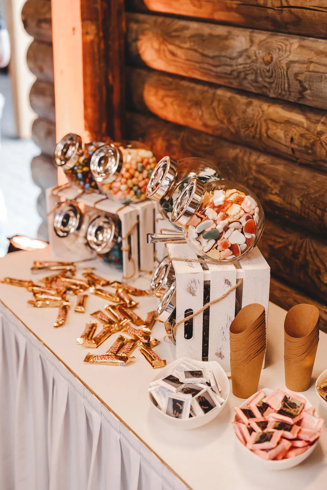 Candybar mit Bonbonspendern, goldenen Riegeln und Papiertüten