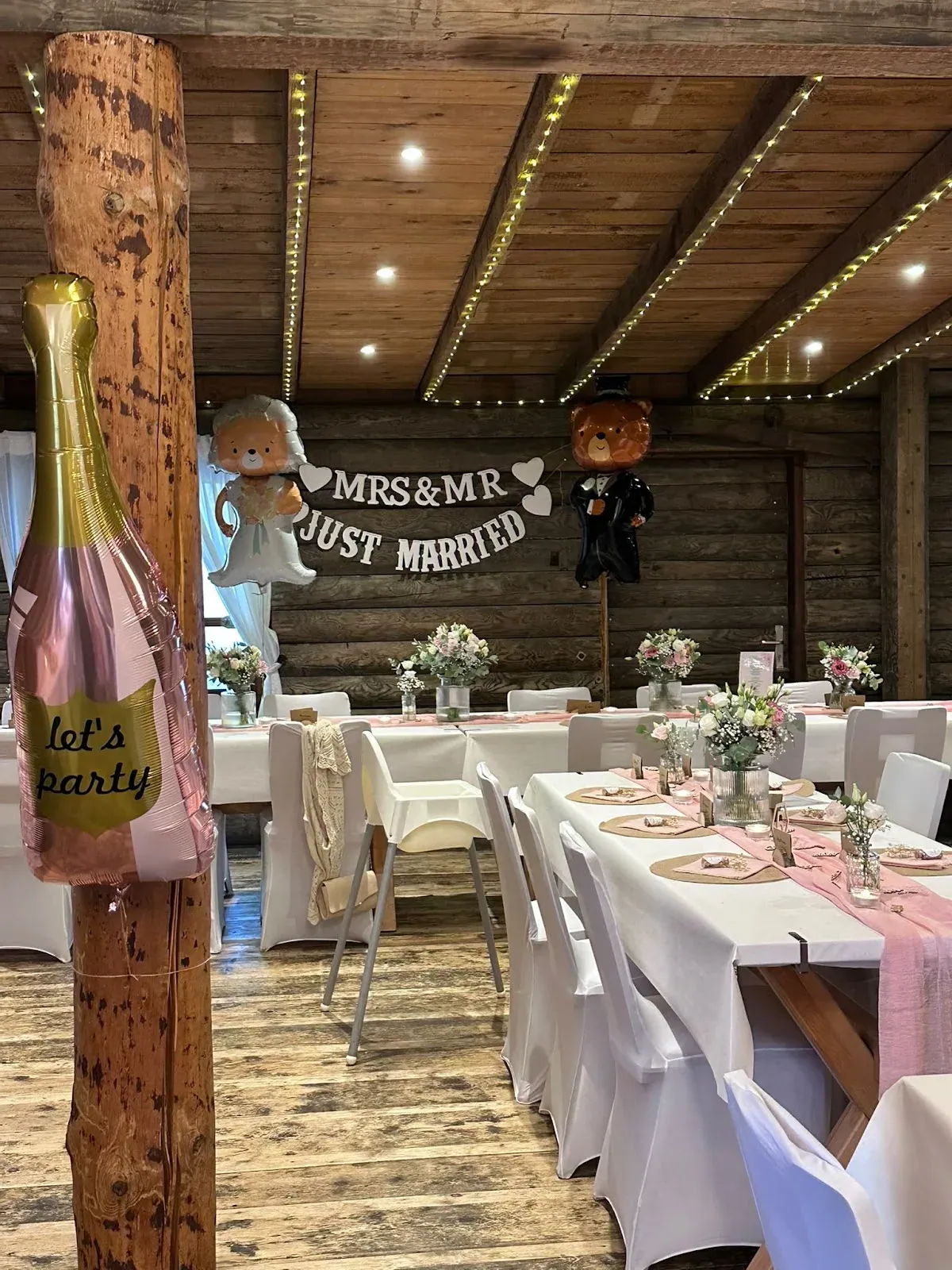 Festsaal zur Hochzeit von Jana mit Schriftzug „Mrs & Mr Just married“ und gedeckten Tafeln