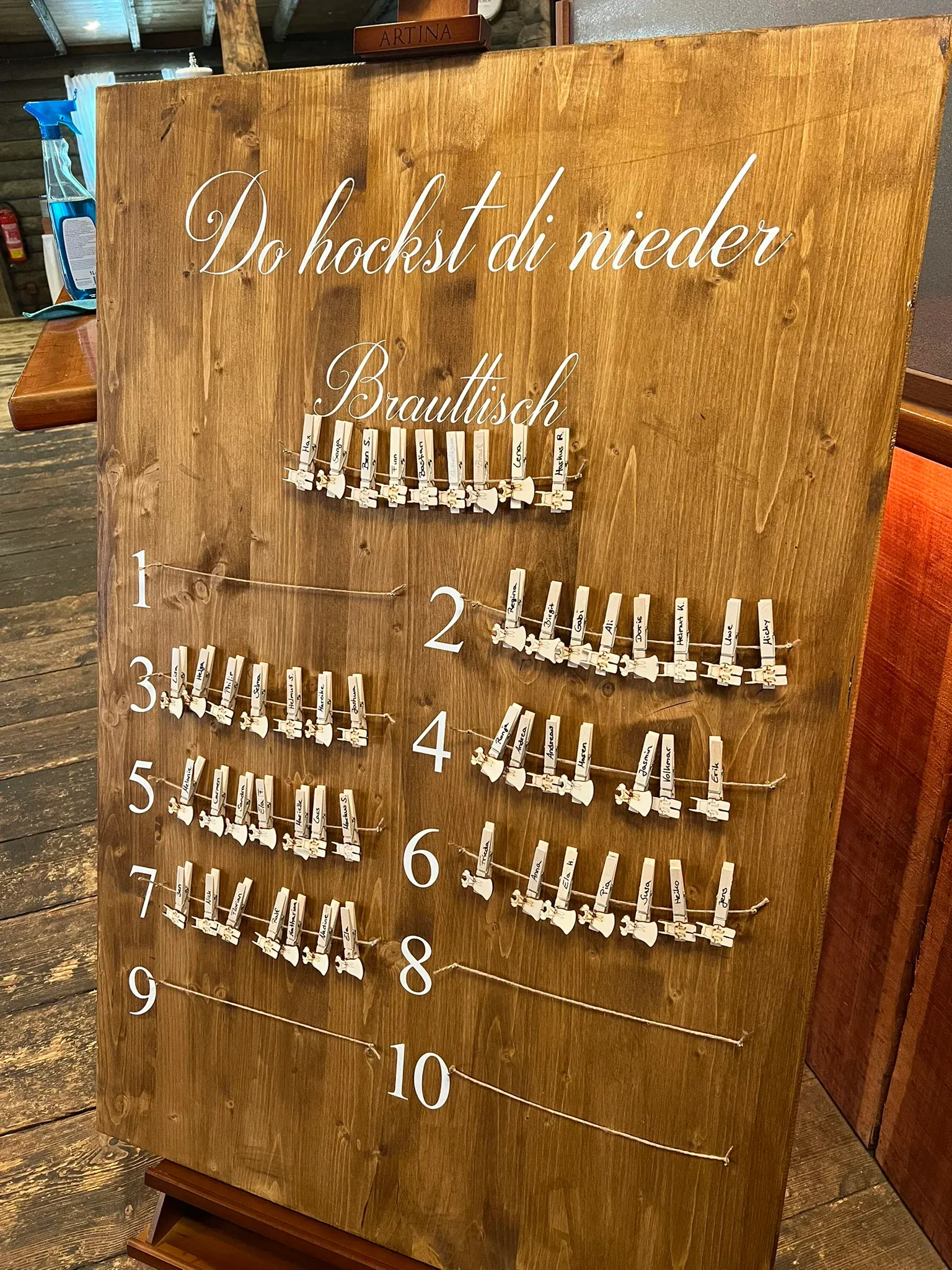 Gästeplan auf einer Holztafel mit Wäscheklammern für jeden Tisch