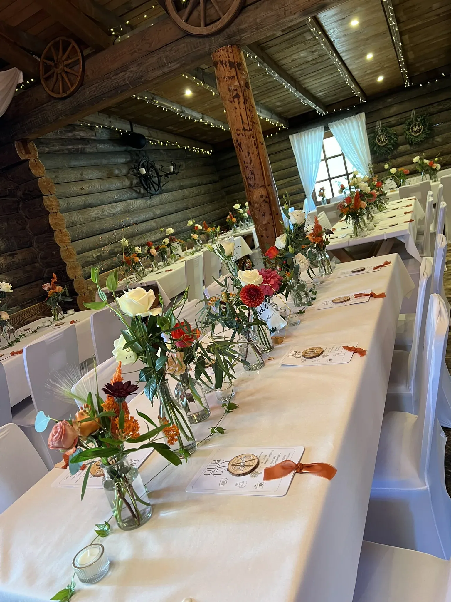 Lange Tafel mit bunten Blumen in kleinen Vasen